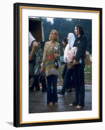 Couple Standing Barefoot on a Road Holding a Bundle and Wine Bottle, Woodstock Music and Art Fair-John Dominis-Framed Photographic Print