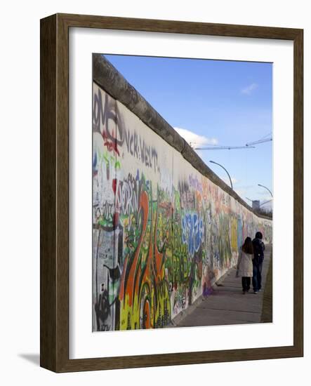 Couple Walking Along the East Side Gallery Berlin Wall Mural, Berlin, Germany, Europe-Simon Montgomery-Framed Photographic Print