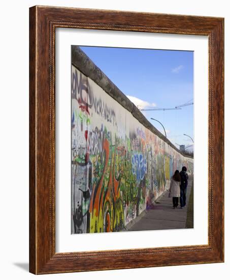 Couple Walking Along the East Side Gallery Berlin Wall Mural, Berlin, Germany, Europe-Simon Montgomery-Framed Photographic Print