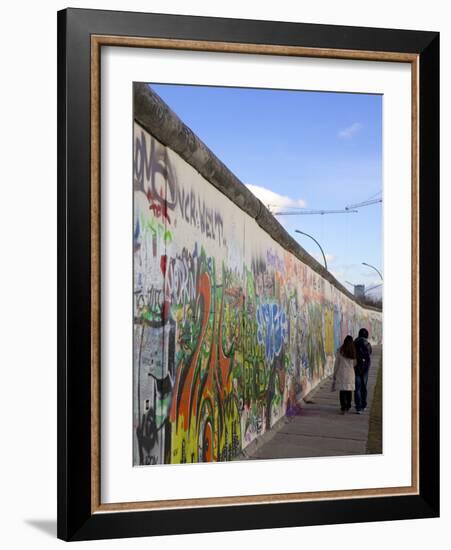 Couple Walking Along the East Side Gallery Berlin Wall Mural, Berlin, Germany, Europe-Simon Montgomery-Framed Photographic Print