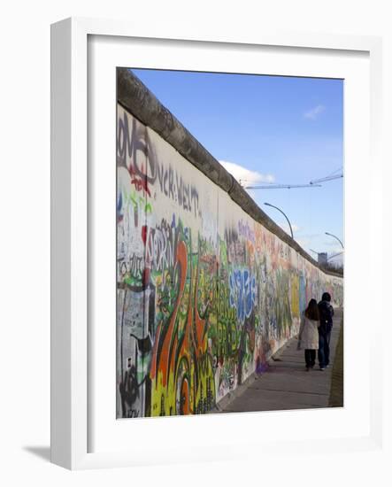 Couple Walking Along the East Side Gallery Berlin Wall Mural, Berlin, Germany, Europe-Simon Montgomery-Framed Photographic Print