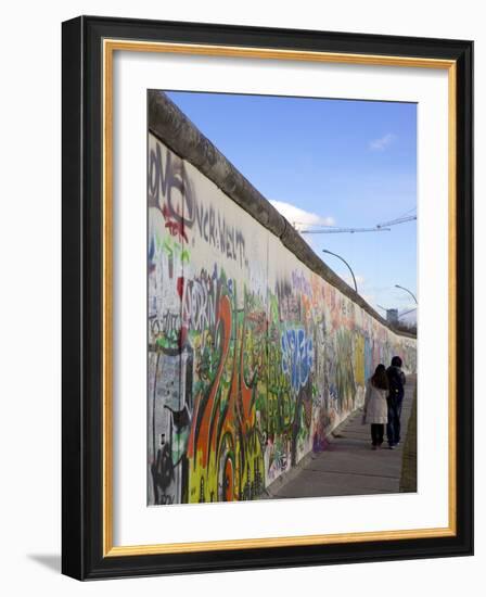 Couple Walking Along the East Side Gallery Berlin Wall Mural, Berlin, Germany, Europe-Simon Montgomery-Framed Photographic Print