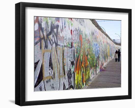 Couple Walking Along the East Side Gallery Berlin Wall Mural, Berlin, Germany, Europe-Simon Montgomery-Framed Photographic Print