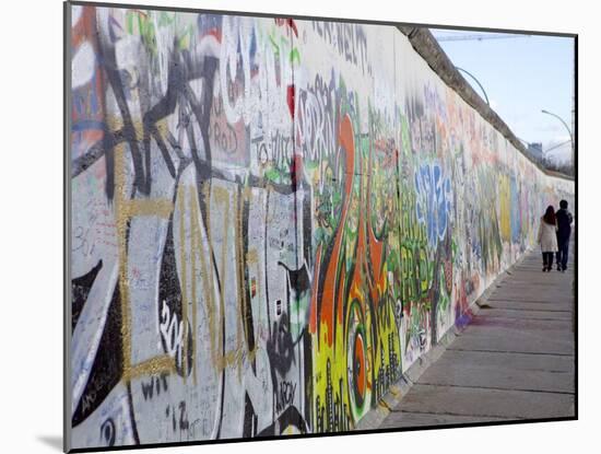 Couple Walking Along the East Side Gallery Berlin Wall Mural, Berlin, Germany, Europe-Simon Montgomery-Mounted Photographic Print