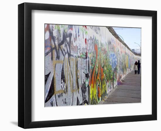 Couple Walking Along the East Side Gallery Berlin Wall Mural, Berlin, Germany, Europe-Simon Montgomery-Framed Photographic Print