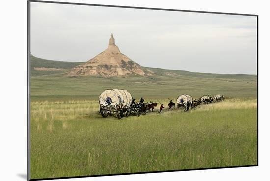 Covered Wagons Passing Chimney Rock, a Landmark on the Oregon Trail, Nebraska-null-Mounted Photographic Print