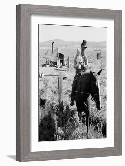 Cowboy Holds His Baby While Riding a Horse-Dorothea Lange-Framed Art Print