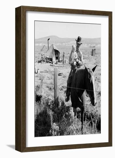 Cowboy Holds His Baby While Riding a Horse-Dorothea Lange-Framed Art Print