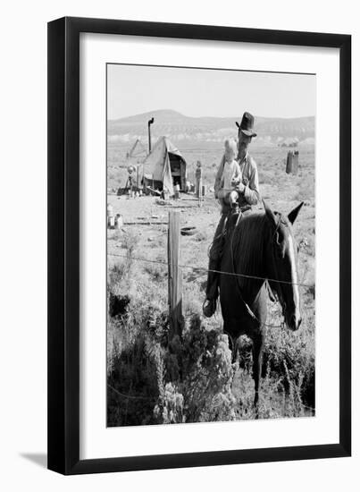 Cowboy Holds His Baby While Riding a Horse-Dorothea Lange-Framed Art Print