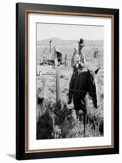 Cowboy Holds His Baby While Riding a Horse-Dorothea Lange-Framed Art Print