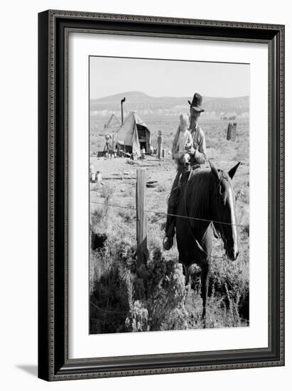 Cowboy Holds His Baby While Riding a Horse-Dorothea Lange-Framed Art Print