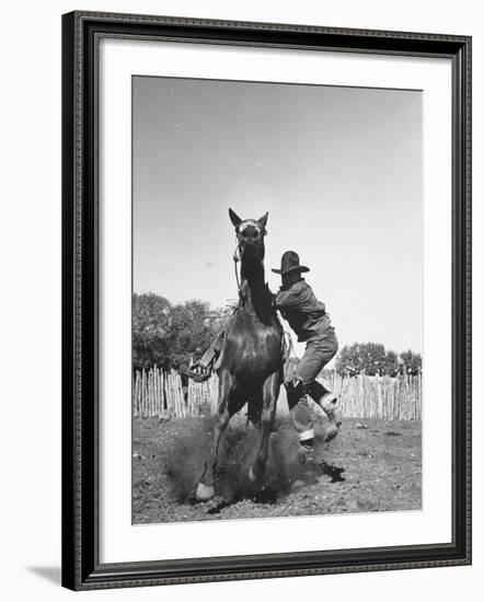 Cowboy Mounting a Horse-Carl Mydans-Framed Photographic Print