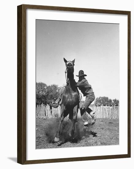 Cowboy Mounting a Horse-Carl Mydans-Framed Photographic Print