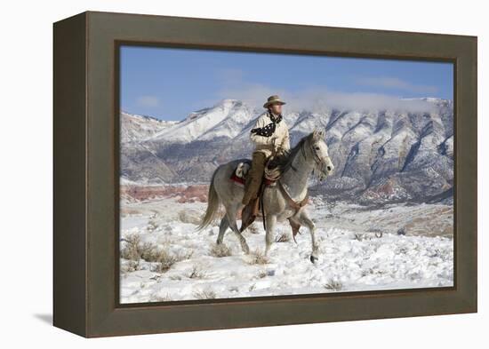 Cowboy On Grey Quarter Horse Trotting In The Snow At Flitner Ranch, Shell, Wyoming-Carol Walker-Framed Premier Image Canvas