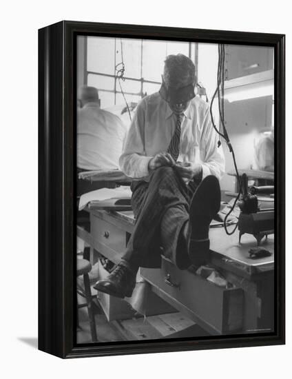 Custom Tailor Ernest Preedik Sitting on Table and Working in Factory-Ralph Morse-Framed Premier Image Canvas