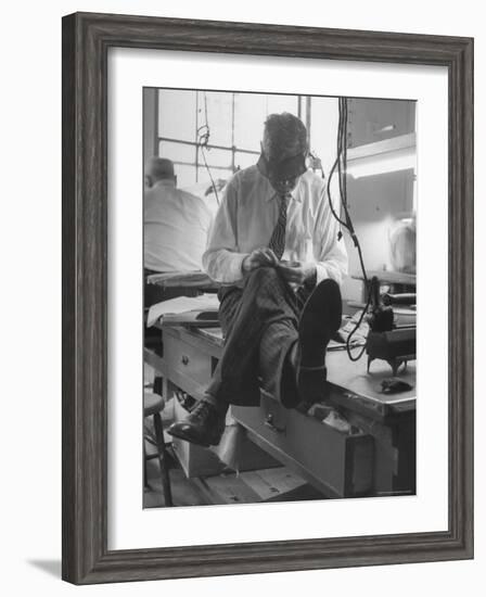 Custom Tailor Ernest Preedik Sitting on Table and Working in Factory-Ralph Morse-Framed Photographic Print