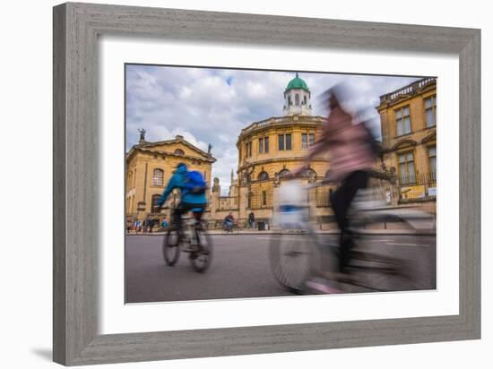 Cyclists Passing the Sheldonian Theatre, Oxford, Oxfordshire, England, United Kingdom, Europe-John Alexander-Framed Photographic Print