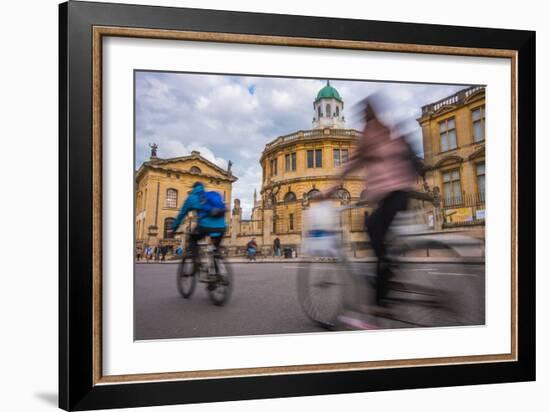 Cyclists Passing the Sheldonian Theatre, Oxford, Oxfordshire, England, United Kingdom, Europe-John Alexander-Framed Photographic Print