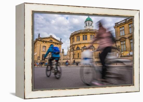 Cyclists Passing the Sheldonian Theatre, Oxford, Oxfordshire, England, United Kingdom, Europe-John Alexander-Framed Premier Image Canvas