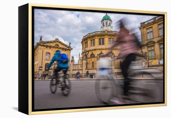 Cyclists Passing the Sheldonian Theatre, Oxford, Oxfordshire, England, United Kingdom, Europe-John Alexander-Framed Premier Image Canvas