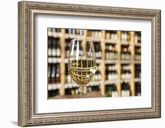 Czech Republic, Prague. Glass of White Wine Reflects Wine Bottle Shelf-Jaynes Gallery-Framed Photographic Print