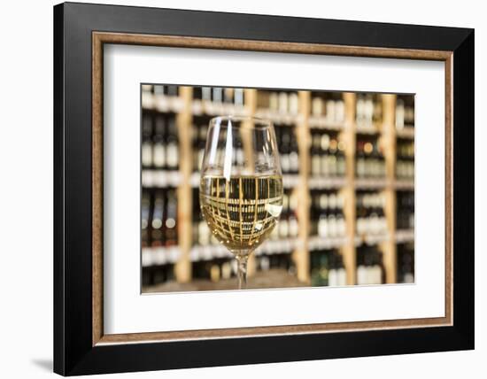 Czech Republic, Prague. Glass of White Wine Reflects Wine Bottle Shelf-Jaynes Gallery-Framed Photographic Print