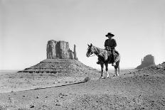 NAVAJO INDIAN IN COWBOY HAT ON HORSEBACK WITH MONUMENT VALLEY ROCK FORMATIONS IN BACKGROUND-D Corson-Photographic Print