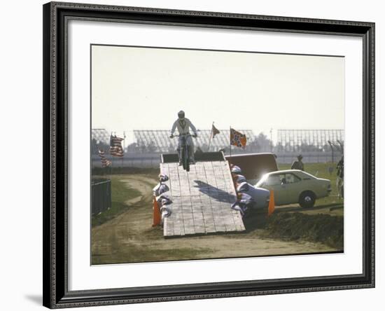 Daredevil Motorcyclist Evel Knievel Rising on Platform During Performance of Stunt-null-Framed Premium Photographic Print