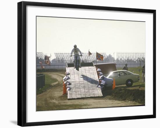 Daredevil Motorcyclist Evel Knievel Rising on Platform During Performance of Stunt-null-Framed Premium Photographic Print