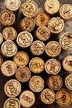 Dated Wine Bottle Corks on the Wooden Background-Dasha Petrenko-Photographic Print