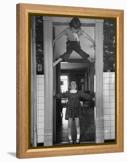 Denise Bruene Climbing Kitchen Door in Bare Feet, Her Hobby, Jan Bruene Says "Don't Fall on Me"-Gordon Parks-Framed Premier Image Canvas