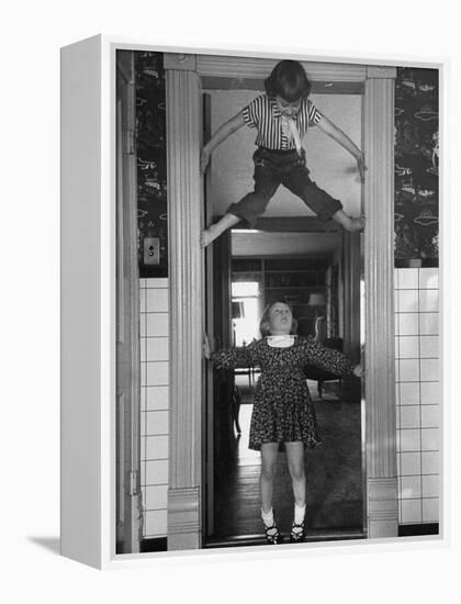 Denise Bruene Climbing Kitchen Door in Bare Feet, Her Hobby, Jan Bruene Says "Don't Fall on Me"-Gordon Parks-Framed Premier Image Canvas