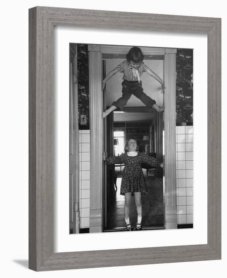 Denise Bruene Climbing Kitchen Door in Bare Feet, Her Hobby, Jan Bruene Says "Don't Fall on Me"-Gordon Parks-Framed Photographic Print
