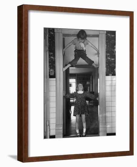 Denise Bruene Climbing Kitchen Door in Bare Feet, Her Hobby, Jan Bruene Says "Don't Fall on Me"-Gordon Parks-Framed Photographic Print