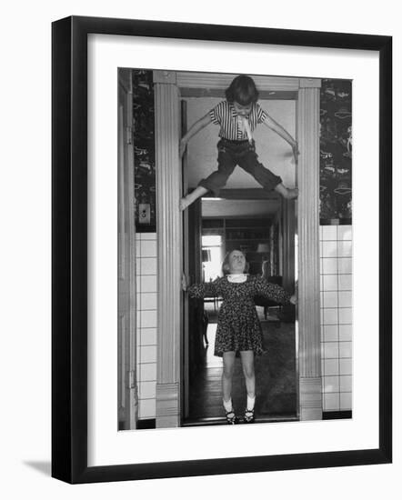 Denise Bruene Climbing Kitchen Door in Bare Feet, Her Hobby, Jan Bruene Says "Don't Fall on Me"-Gordon Parks-Framed Photographic Print