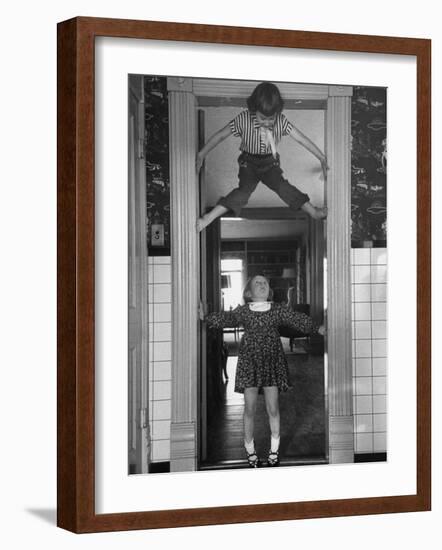 Denise Bruene Climbing Kitchen Door in Bare Feet, Her Hobby, Jan Bruene Says "Don't Fall on Me"-Gordon Parks-Framed Photographic Print