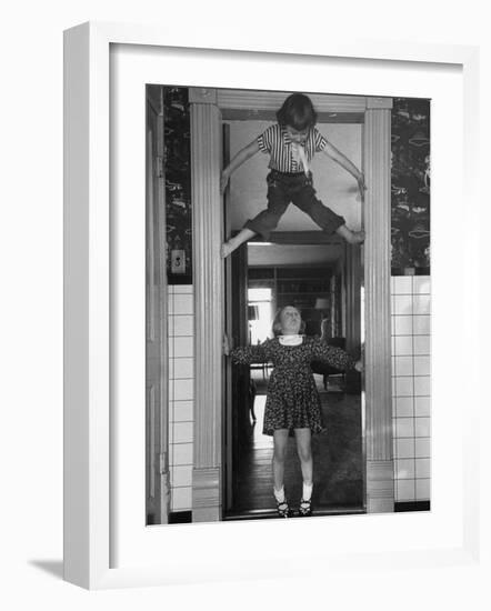 Denise Bruene Climbing Kitchen Door in Bare Feet, Her Hobby, Jan Bruene Says "Don't Fall on Me"-Gordon Parks-Framed Photographic Print