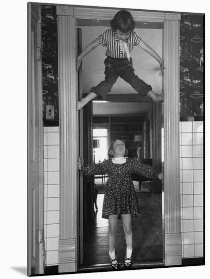 Denise Bruene Climbing Kitchen Door in Bare Feet, Her Hobby, Jan Bruene Says "Don't Fall on Me"-Gordon Parks-Mounted Photographic Print