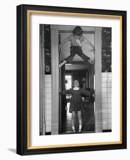 Denise Bruene Climbing Kitchen Door in Bare Feet, Her Hobby, Jan Bruene Says "Don't Fall on Me"-Gordon Parks-Framed Photographic Print