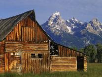 Weathered Wooden Barn Along Mormon Row with the Grand Tetons in Distance, Grand Teton National Park-Dennis Flaherty-Photographic Print