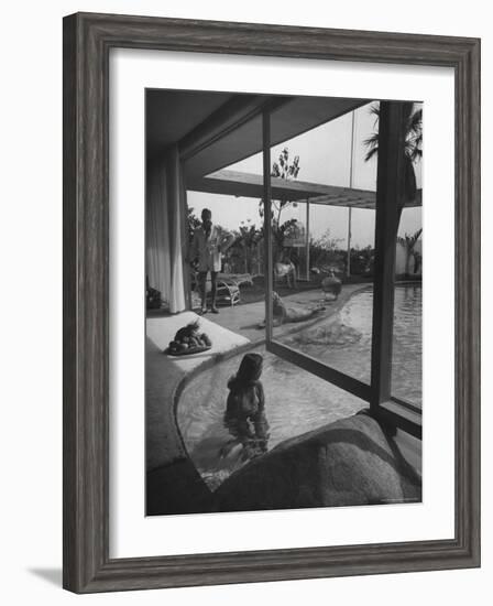 Designer Raymond Loewy Relaxing by Swimming Pool Which Runs from Outdoors Into Living Room-Peter Stackpole-Framed Premium Photographic Print