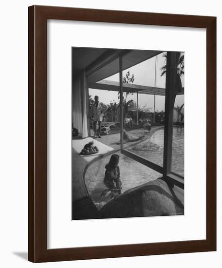 Designer Raymond Loewy Relaxing by Swimming Pool Which Runs from Outdoors Into Living Room-Peter Stackpole-Framed Premium Photographic Print