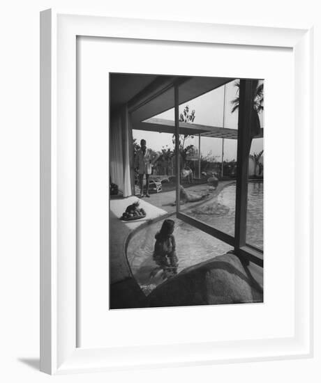 Designer Raymond Loewy Relaxing by Swimming Pool Which Runs from Outdoors Into Living Room-Peter Stackpole-Framed Premium Photographic Print