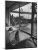 Designer Raymond Loewy Relaxing by Swimming Pool Which Runs from Outdoors Into Living Room-Peter Stackpole-Mounted Premium Photographic Print