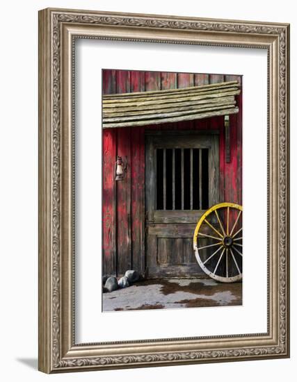 Detail of Old Wagon Wheel next to a Wooden Wild West Typical House-ccaetano-Framed Photographic Print