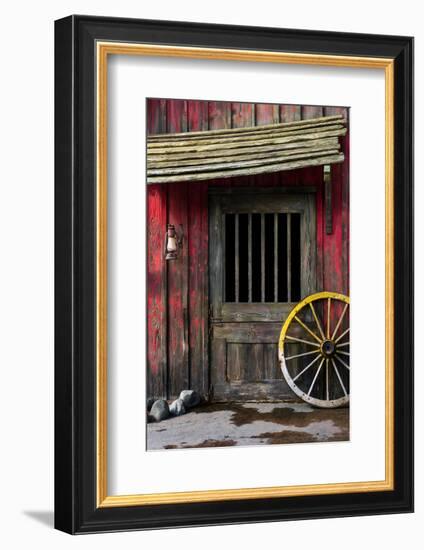 Detail of Old Wagon Wheel next to a Wooden Wild West Typical House-ccaetano-Framed Photographic Print