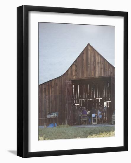 Diners Enjoying A Locally Sourced Dinner Inside An Old Barn In Sierraville Valley, California-Shea Evans-Framed Photographic Print