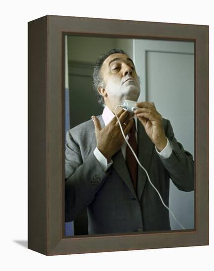 Director Federico Fellini with Powder on His Face as He Shaves with an Electric Shaver-Carlo Bavagnoli-Framed Premier Image Canvas