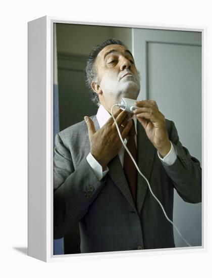 Director Federico Fellini with Powder on His Face as He Shaves with an Electric Shaver-Carlo Bavagnoli-Framed Premier Image Canvas