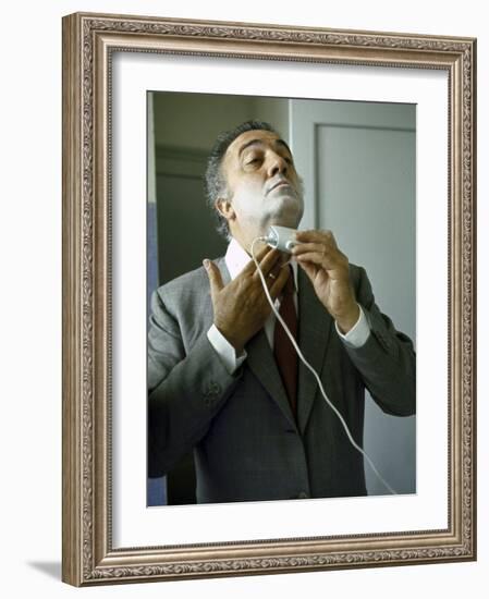 Director Federico Fellini with Powder on His Face as He Shaves with an Electric Shaver-Carlo Bavagnoli-Framed Photographic Print